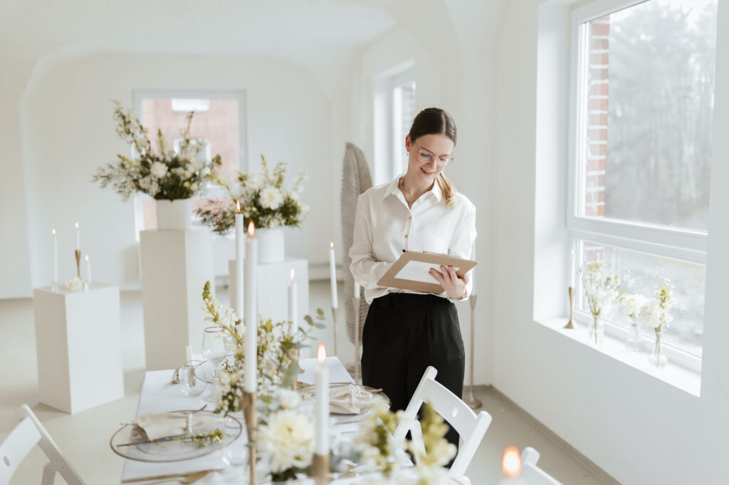 Hochzeitsplanerin mit Klemmbrett vor Tischdekoration in Mecklenburg-Vorpommern